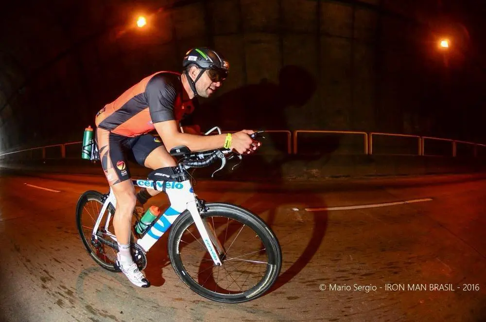 Dênis pedalando à noite no Ironman de 2016
